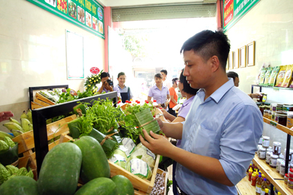 Người tiêu dùng ủng hộ việc gói rau bằng lá chuối tại Cửa hàng nông sản an toàn Trang Quyết, huyện Gia Viễn. Ảnh: Anh Tuấn