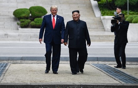 Tổng thống Mỹ Donald Trump (trái) và nhà lãnh đạo Triều Tiên Kim Jong-un (giữa) trong cuộc gặp tại Khu phi quân sự (DMZ) ở biên giới liên Triều chiều 30/6/2019. (Ảnh: AFP/TTXVN)