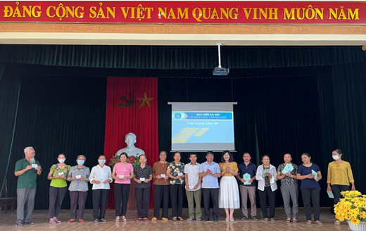 Lãnh đạo BHXH huyện Hoa Lư trao sổ cho người tham gia BHXH tự nguyện, BHYT hộ gia đình.