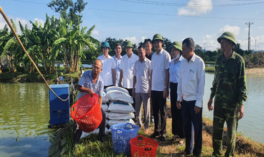 Lãnh đạo Hội Nông dân tỉnh trao cá giống và cám cho thành viên chi Hội nghề nghiệp nuôi cá nước ngọt trong ao xã Văn Phong (huyện Nho Quan)